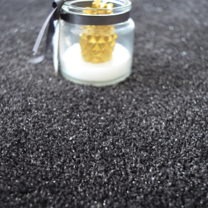 Détail moquette Paillettes Star Noir avec effet paillettes et bougie posée sur surface brillante