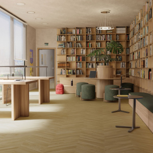 Sol vinyle Batimax Olympus T36 imitation parquet en chevrons point de Hongrie dans un espace lumineux avec bibliothèque et mobilier en bois