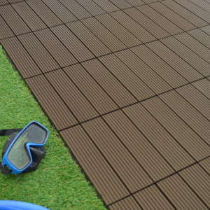 Dalles de terrasse composite chocolat posées près d'un gazon synthétique