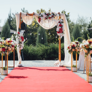 Moquette filmée Stand Event - Rose Candy installée devant une arche florale pour cérémonie de mariage