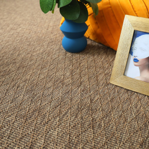 Tapis intérieur / extérieur Timika - Marron camel - Galon noir, tissage plat dans un intérieur avec coussin orange, vase bleu et cadre photo