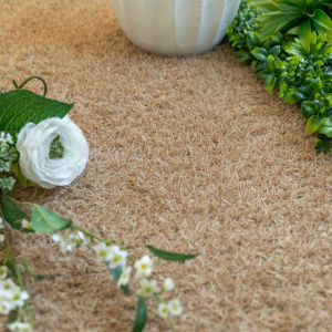 Gazon synthétique de couleur Métropolitain Sable - 22 mm avec fleurs blanches et feuillage vert dans un jardin décoratif