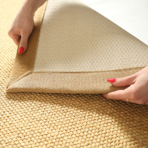Détail de l’envers du tapis sisal Tulum miel avec la ganse en lin camel 