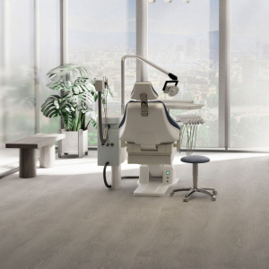 Sol vinyle Batimax Elias T94 imitation bois gris clair dans un cabinet dentaire moderne avec fauteuil de soins et grandes baies vitrées