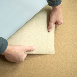 Moquette filmée Stand Event beige retournée montrant l’envers du revêtement événementiel