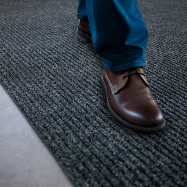 Tapis d’entrée anthracite, contraste raffiné avec chaussures marron