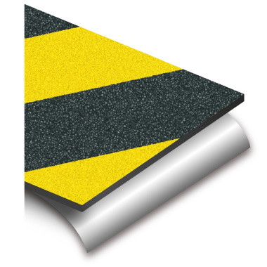 Gros plan sur adhésif antidérapant noir et jaune, surface granuleuse haute adhérence