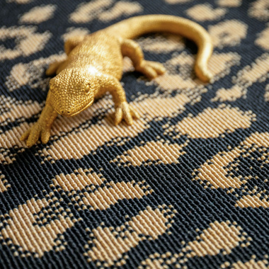 Tapis léopard noir et doré avec motif animalier et objet décoratif doré