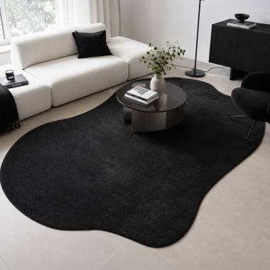 Tapis contemporain de forme organique Hypnose - Noir velours sur tapis en fibres naturelles dans un salon raffiné