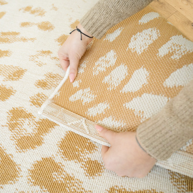 Tapis léopard crème et doré, finition soignée et tissage résistant