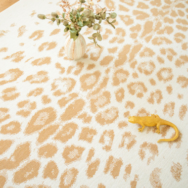 Tapis léopard crème et doré dans un salon lumineux, motif animal chic et graphique
