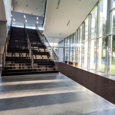 Tapis d'entrée marron au design côtelé dans un bâtiment moderne – antisalissures & antidérapant