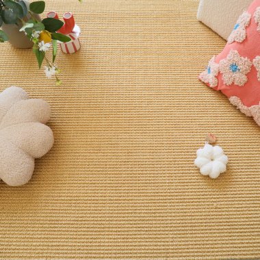 Sol en sisal grosses boucles Cancun Naturel avec coussins et objets déco dans un intérieur chaleureux