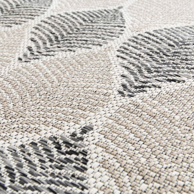 Zoom sur le tapis Essenza, motif feuilles gris et beige tissé plat