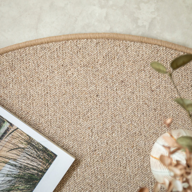 Détail du bord surjeté du tapis ovale Mallow beige en laine bouclée