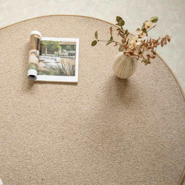 Tapis ovale Mallow beige en laine avec vase décoratif et magazine