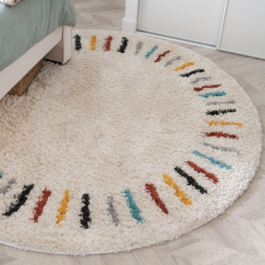 Tapis rond chambre d'enfant berbère Adel - Beige et traits multicolores apportant une note joyeuse près du lit