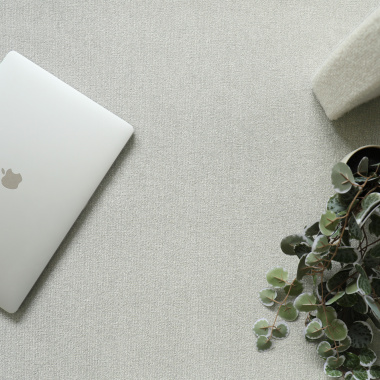 Moquette Sylon gris galet avec accessoires décoratifs posés sur le sol textile