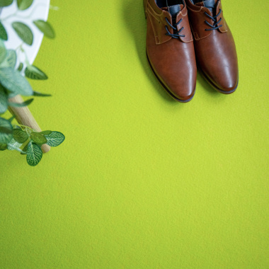 Moquette filmée Stand Event Vert pomme avec chaussures posées, usage stand professionnel