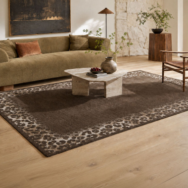 Tapis de salon Sauvage marron chocolat - Motif léopard associé à un mobilier en bois dans une ambiance cosy