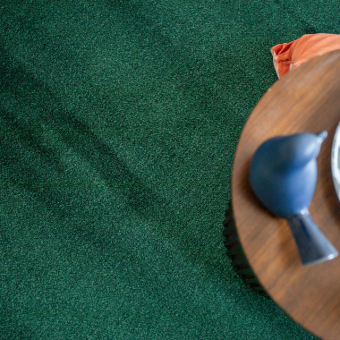 Moquette ultra douce Pulse vert forêt, détail texture velours avec plateau bois
