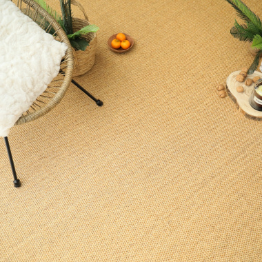 Espace détente avec fauteuil sur le tapis en sisal Tulum miel, ambiance chaleureuse et naturelle