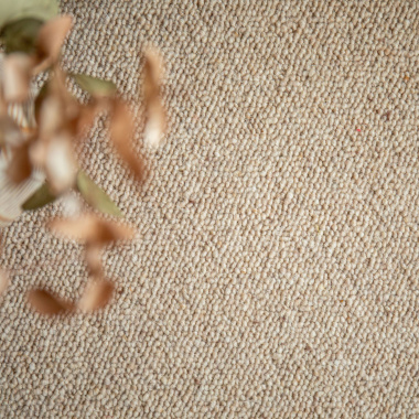 Gros plan sur la texture en laine bouclée du tapis ovale Mallow beige
