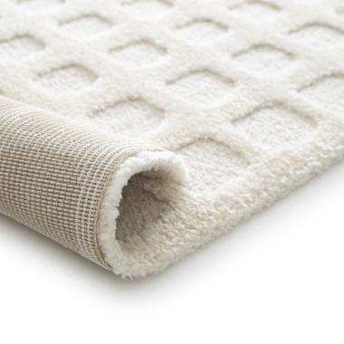 Vue du tapis de salon Art Abstrait crème roulé, avec texture épaisse en relief et dos tissé