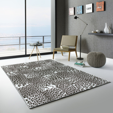 Tapis toucher soft léopard Patchwork noir et blanc posé sur sol clair dans un salon moderne
