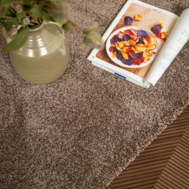 Tapis sur mesure Select Chocolat, velours épais mis en scène avec vase et magazine