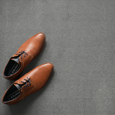 Chaussures en cuir et accessoires décoratifs posés sur un tapis sur mesure Sylon Gris minéral haute résistance