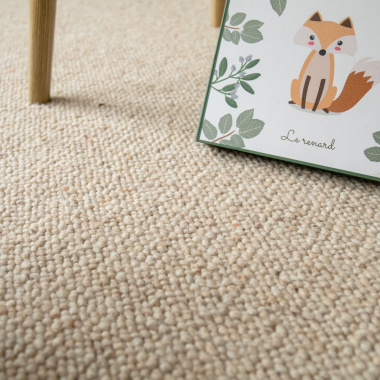 Moquette Latoon grège en pure laine vierge bouclée dans une ambiance douce de chambre avec illustration