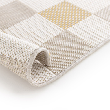 Zoom sur le bord roulé du tapis Andy en matière recyclée, motif damier beige et ocre