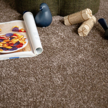 Tapis sur mesure Select Chocolat – Résistant aux taches, vue déco avec magazine et objets