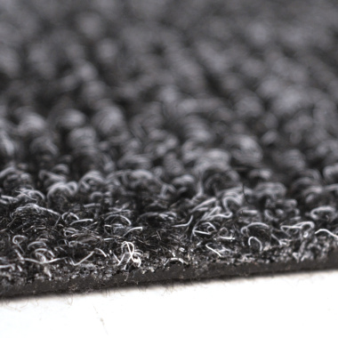Zoom sur la texture bouclée de la dalle moquette anthracite avec détail matière et fibres résistantes