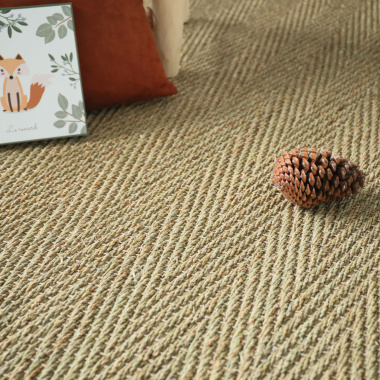 Ambiance nature sur le tapis jonc de mer Assam, fibres végétales et coussins en velours