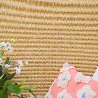 Fleurs et coussin décoratif sur le sol en sisal grosses boucles Cancun Naturel, ambiance naturelle et douce