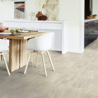 Sol PVC effet carrelage calcaire grège posé dans une salle à manger lumineuse
