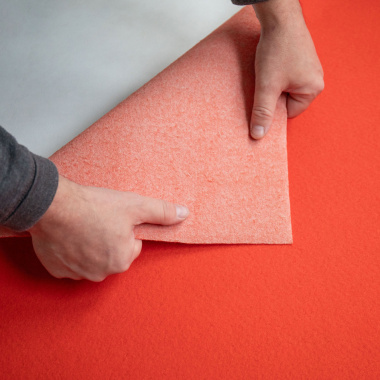 Moquette filmée aiguilletée stand event Orange sanguine montrant le dessous du revêtement retourné