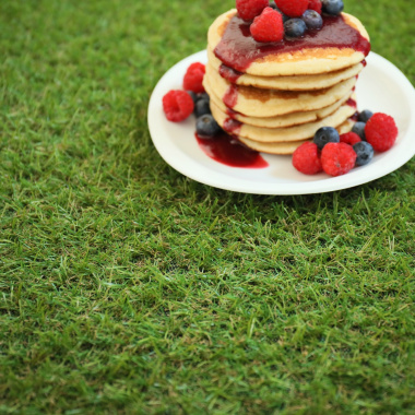 Gros plan sur des pancakes aux fruits rouges posés sur Gazon synthétique Brunch 18 mm, texture réaliste et douce