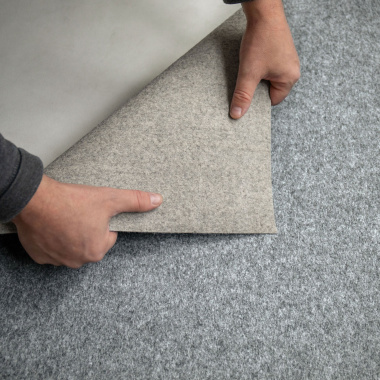 Envers de moquette filmée stand event gris visible, revêtement textile utilisé pour salons professionnels