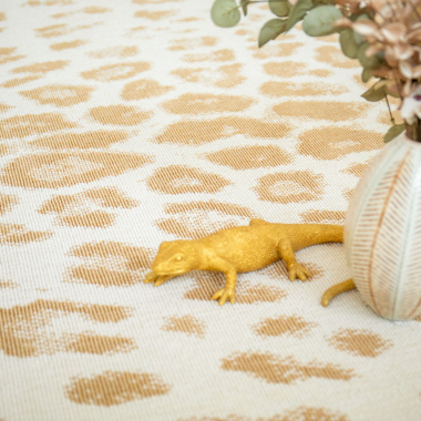Tapis de salon léopard crème avec touches dorées, ambiance déco élégante et tendance