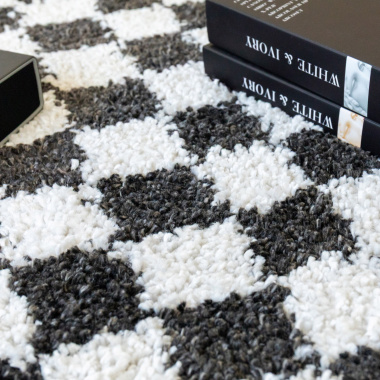 Tapis damier à poils longs Colorama - Noir et blanc dévoilant son motif graphique dans une ambiance rétro