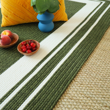 Gros plan sur le tapis Provence vert forêt posé sur un sol en fibres naturelles tressées