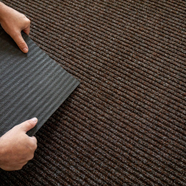 Gros plan sur le tapis d’entrée côtélé marron, verso gel antidérapant