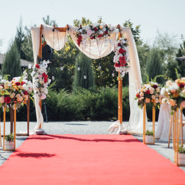 Moquette filmée Stand Event - Rose Candy installée devant une arche florale pour cérémonie de mariage