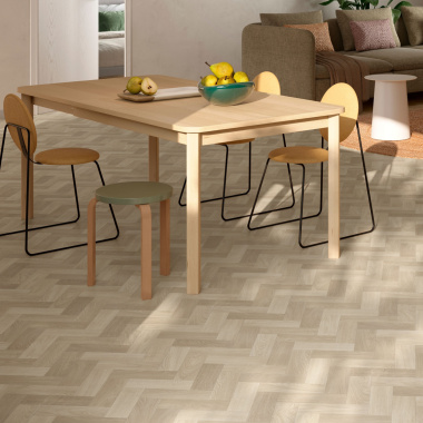 Sol vinyle Prestige Batitec - Sintra T45, décor bois en chevrons dans une salle à manger avec table rectangulaire et chaises en bois