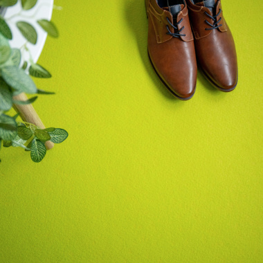 Moquette filmée Stand Event Vert pomme avec chaussures posées, usage stand professionnel