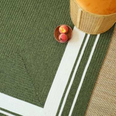 Détail du tapis Provence en matière synthétique vert forêt sur sol tressé naturel