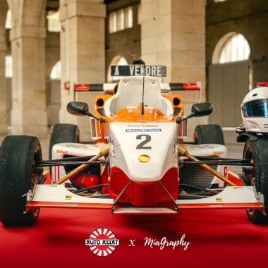 Voiture de course exposée sur moquette Stand Expo - Rouge vif filmé pour événement